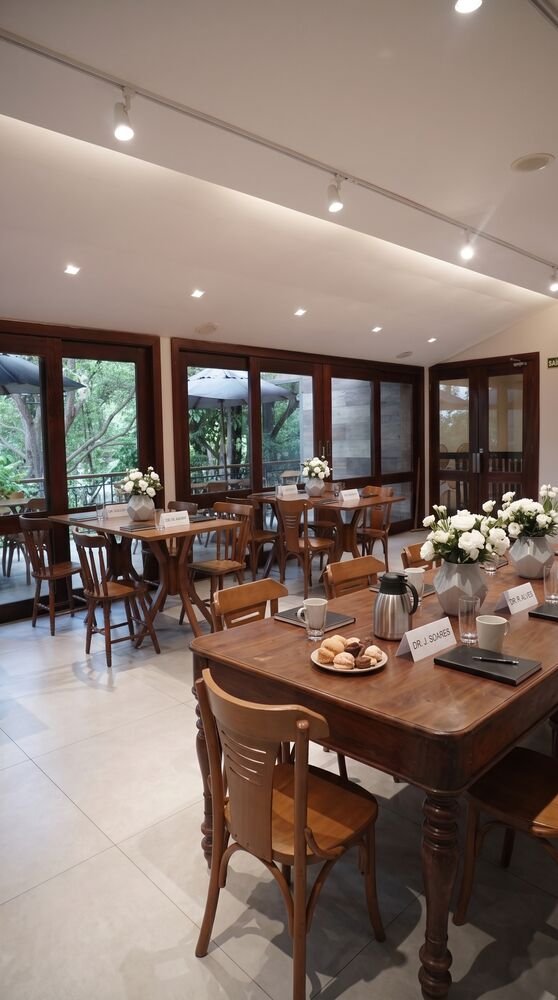 Salão do Terrazo com mesas montadas e vista para a varanda arborizada, Fortaleza
